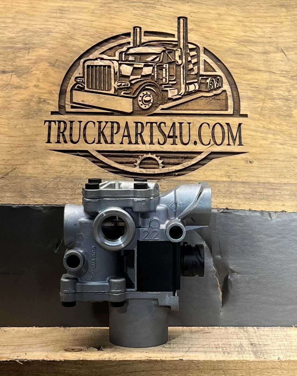 Front view of Meritor WABCO 400-611-002-0 ABS modulator valve for heavy-duty truck air brake systems, shown against TruckParts4U.com branded wood background.